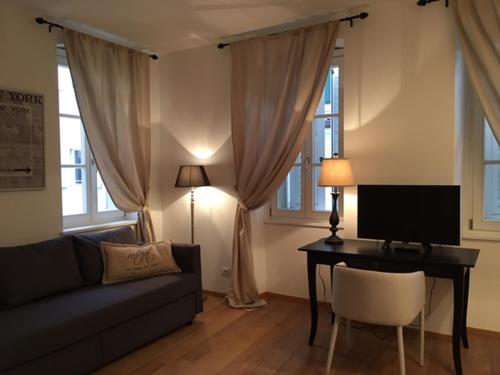 a living room with a couch and a desk with a television at Barbacan Boutique Hotel in Trieste