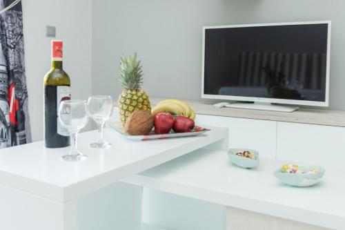 a white counter with a plate of fruit and wine glasses at Maritina Apartments in Ixia