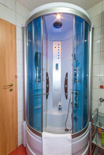Un baño con ducha de cristal azul. en Apartments Kira, en Sarajevo