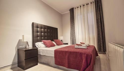 バルセロナにあるAlcam Lessepsのベッドルーム1室(赤毛布付きの大型ベッド1台付)