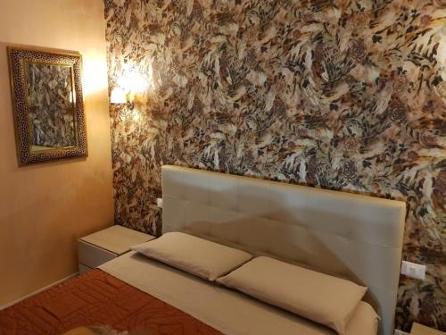 a bedroom with a white bed with a floral wallpaper at Le Cale' B&B in San Severo
