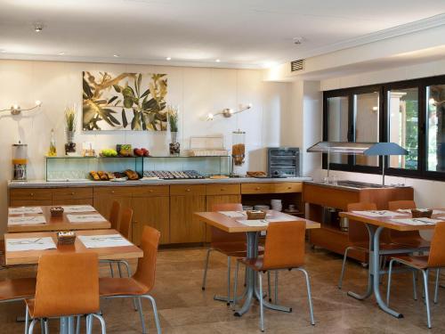 restauracja ze stołami i krzesłami oraz kuchnią w obiekcie Apartamentos TH La Florida w Madrycie