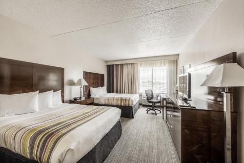 a hotel room with two beds and a desk at Country Inn & Suites by Radisson, Cookeville, TN in Cookeville