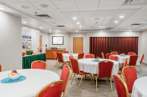 a conference room with white tables and red chairs at Country Inn & Suites by Radisson, Cookeville, TN in Cookeville