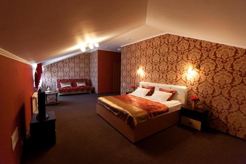 チュメニにあるVoiazh Hotelのベッドとソファ付きのホテルルーム