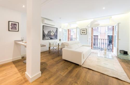 a living room with a white couch and a table at Atocha Museos - Barrio de las Letras in Madrid