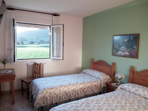 a hotel room with two beds and a window at Posada Gran Sol in Queveda