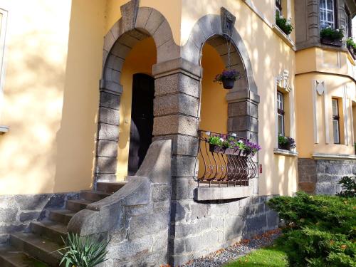 an entrance to a building with a balcony and stairs at Penzion Romance in Vyšší Brod