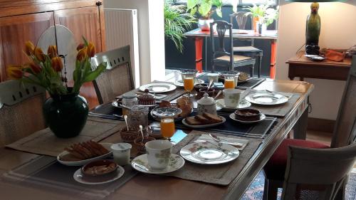 a table set with breakfast foods and orange juice at Les Chambres Buissonnieres in Ladoix Serrigny