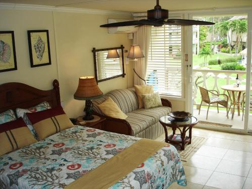 a bedroom with a bed and a couch and a table at Islander on the Beach Unit 244 in Kapaa