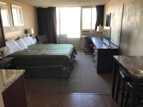 a hotel room with a bed and a desk at Allen Park Motor Lodge in Allen Park