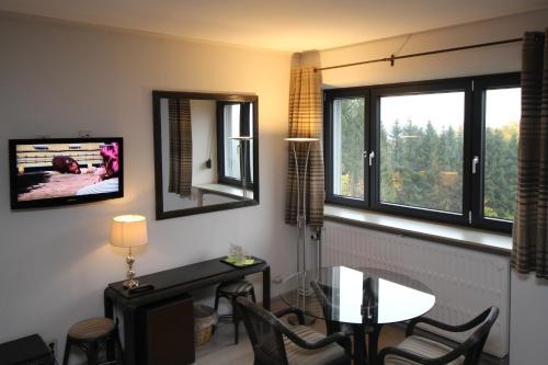 a living room with a table and a window at Les Alisiers in Nadrin