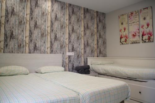 - une chambre avec 2 lits et des murs en bois dans l'établissement Apartamentos Logroño Centro, à Logroño