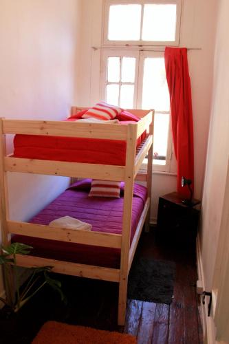 a bedroom with two bunk beds and a window at Casa Volante Hostal in Valparaíso