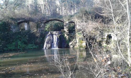 a bridge over a river with a waterfall at Villa Gazounette in Castelmayran