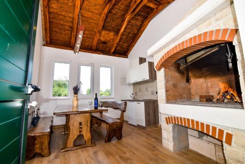 a kitchen with a table and a fireplace at Villa Lily in Privlaka