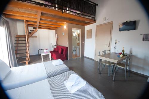 ein Schlafzimmer mit einem Bett, einem Tisch und einem Sofa in der Unterkunft Elounda Sunrise Apartments in Elounda