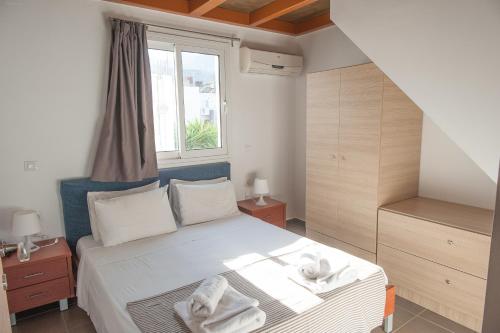 a bedroom with a bed with towels on it at Elounda Sunrise Apartments in Elounda