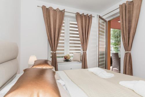 sypialnia z łóżkiem i dużym oknem w obiekcie Grace Apartment I w Kołobrzegu
