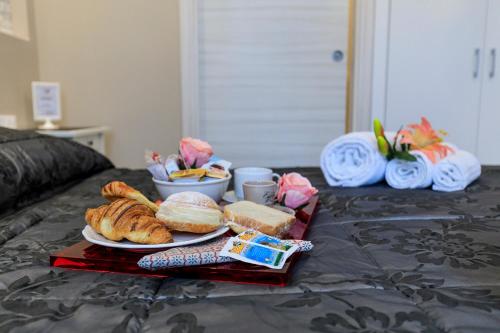 a tray of bread and pastries on a bed at Maison degli Artisti in Ravenna