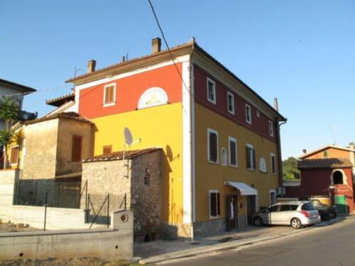 um edifício colorido com um carro estacionado em frente em B&B e Locazioni Turistiche Antico Borgo Toscano em Montecatini Terme