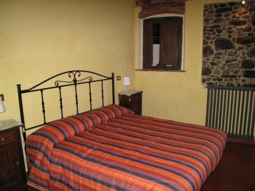 um quarto com uma cama grande e um cobertor listrado em B&B e Locazioni Turistiche Antico Borgo Toscano em Montecatini Terme