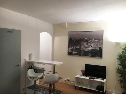 パリにあるCosy Apartment near Eiffel Tourのリビングルーム(テーブル、テレビ付)