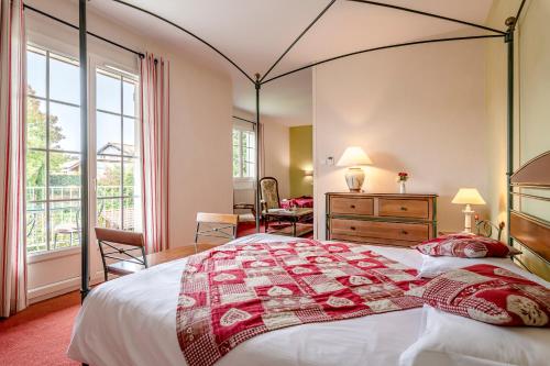 a bedroom with a large bed with a large window at Le Moulin du Gastronome in Charnay-lès-Mâcon