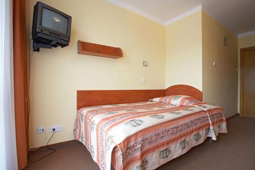 a bedroom with a bed and a tv on the wall at Geovita Muszyna in Muszyna