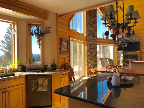 eine Küche mit Holzwänden und Fenstern in einer Hütte in der Unterkunft Cozy Cove Inn in Homer