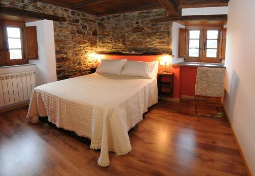 A PontenovaにあるApartamentos Casa Ramoncínのレンガの壁、ベッド付きのベッドルーム1室
