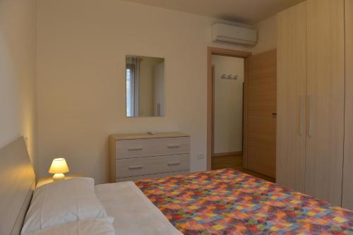 1 dormitorio con cama, tocador y espejo en Residence Boschetti, en Manerba del Garda