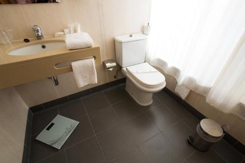 a bathroom with a toilet and a sink at Hotel Solaris in Setúbal