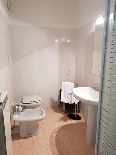 a white bathroom with a toilet and a sink at Casa Vacanza Isola in Orta San Giulio