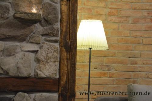 a lamp in a room next to a brick wall at Hotel & Café Mohrenbrunnen in Eisenberg