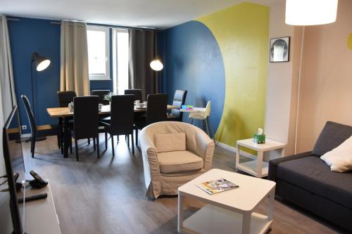 a living room with a couch and a table with chairs at Grand Appartement Vue Cathédrale in Metz