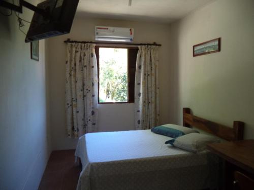 a bedroom with two beds and a window at Chalés Xibayka Ilhabela in Ilhabela