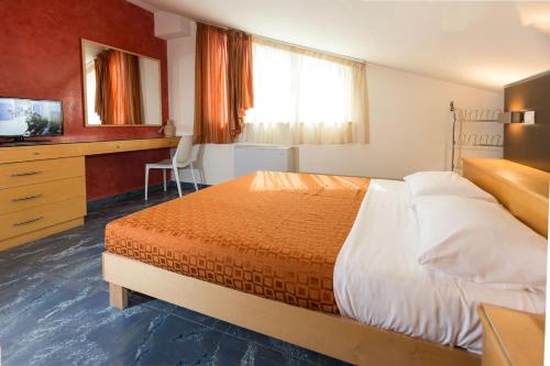 - une chambre avec un lit, un bureau et une télévision dans l'établissement Residence Anchisemare, à Alba Adriatica