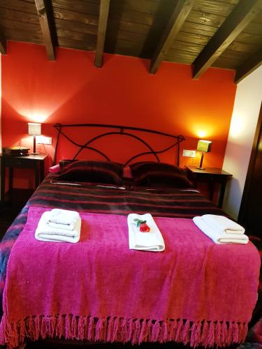 a bedroom with a large bed with towels on it at Apartamentos El Rincon Encantado in Llano-Con