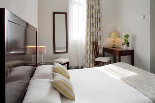 A bed or beds in a room at Hôtel Relais Acropolis