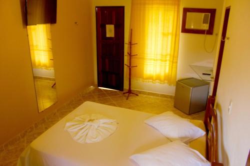 a room with a white table with two pillows at Pousada Lagoa Azul in Jacumã