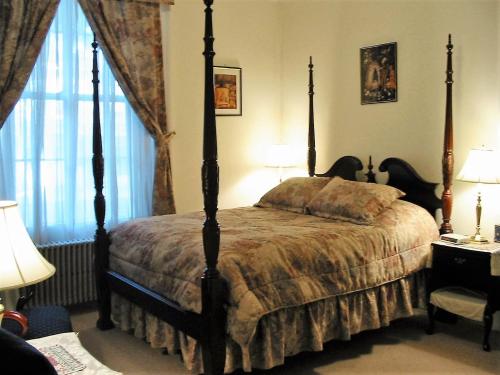 The Historic Mansion في نيو هافن: غرفة نوم بها سرير بأربعة أعمدة ونافذة