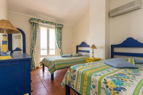 una camera da letto con due letti e una finestra di Marina de Vilamoura Apart a Vilamoura