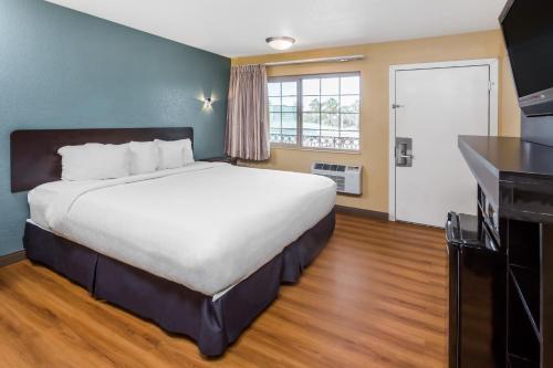 a hotel room with a large bed and a kitchen at Econo Lodge in Oceanside
