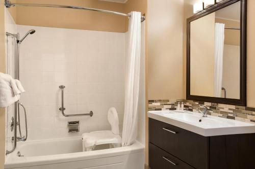 y baño con bañera, lavabo y aseo. en Travelodge by Wyndham Kenora, en Kenora