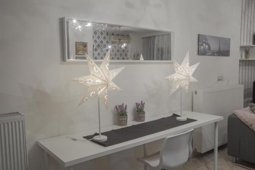 een wit bureau met drie sterren decoraties erop bij Luxury City Center Apartment in Kalabaka