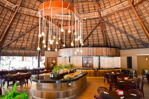 a restaurant with a bar and tables and chairs at Reef Yucatán All Inclusive & Convention Center in Telchac Puerto