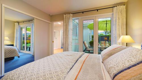a bedroom with a bed and a sliding glass door at Olive House Bed and Breakfast in Christchurch