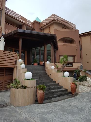 a building with stairs in front of it with potted plants at Hotel Santa Caterina in Fisciano