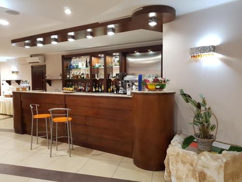 a bar in a restaurant with two stools at Hotel Santa Caterina in Fisciano